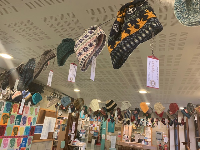 Just a few of the more than one hundred hats sent from all over the world, hanging in the Orkney Library and Archive.